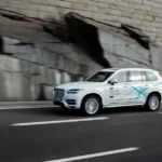 یک خودروی خودران ولوو، بدون علامت، در حال رانندگی در خیابان شهر.